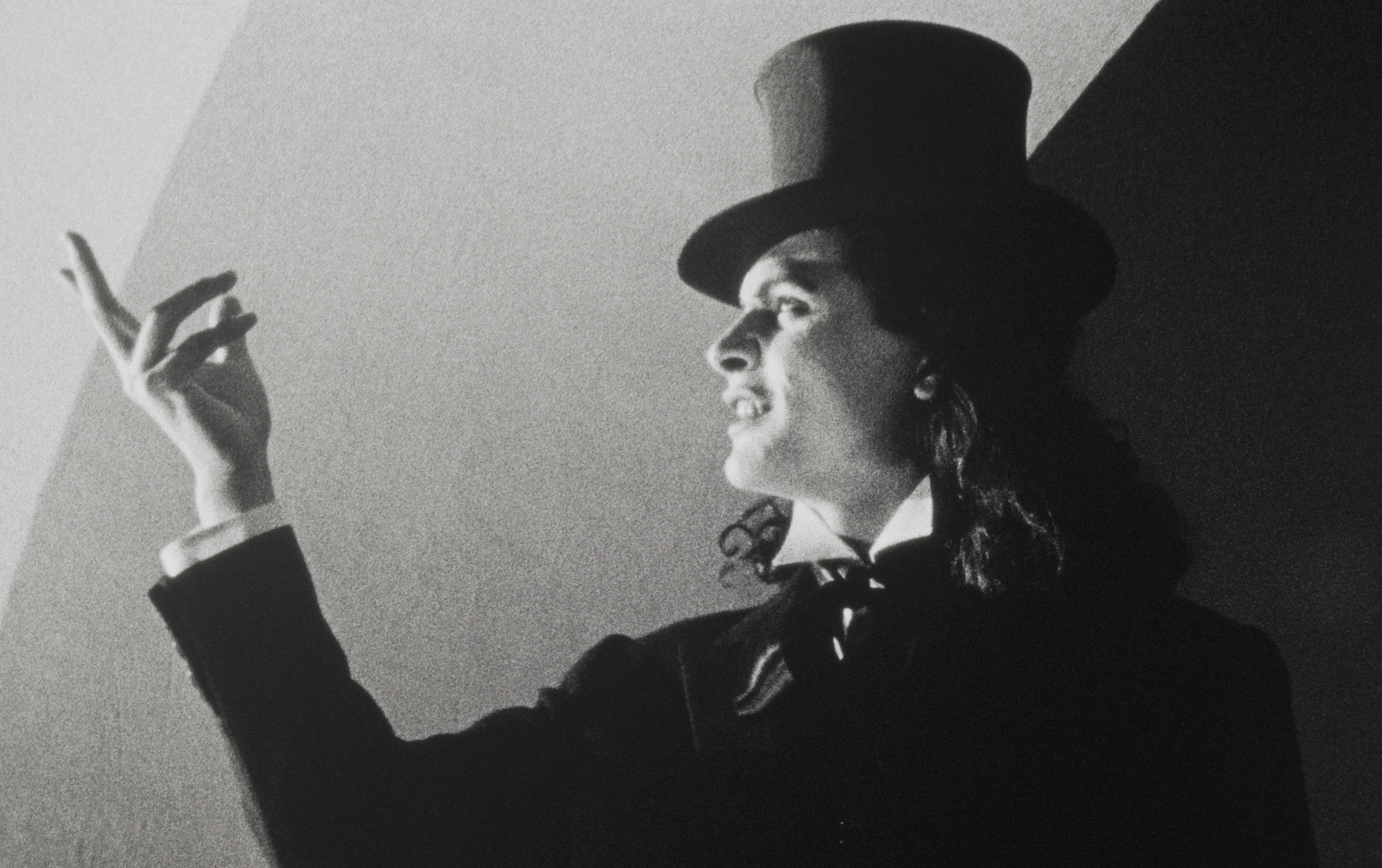 1930s magician in black top hat making a gesture with his hand
